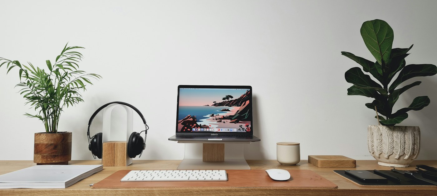 Wooden home office desk with a computer and plants