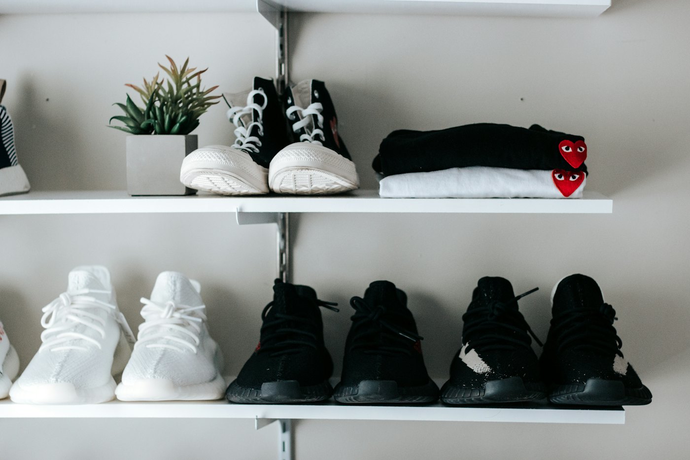 Three pairs of shoes on a floating wall shelf