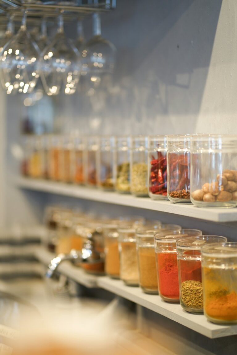 A row of glass jars filled with different spices