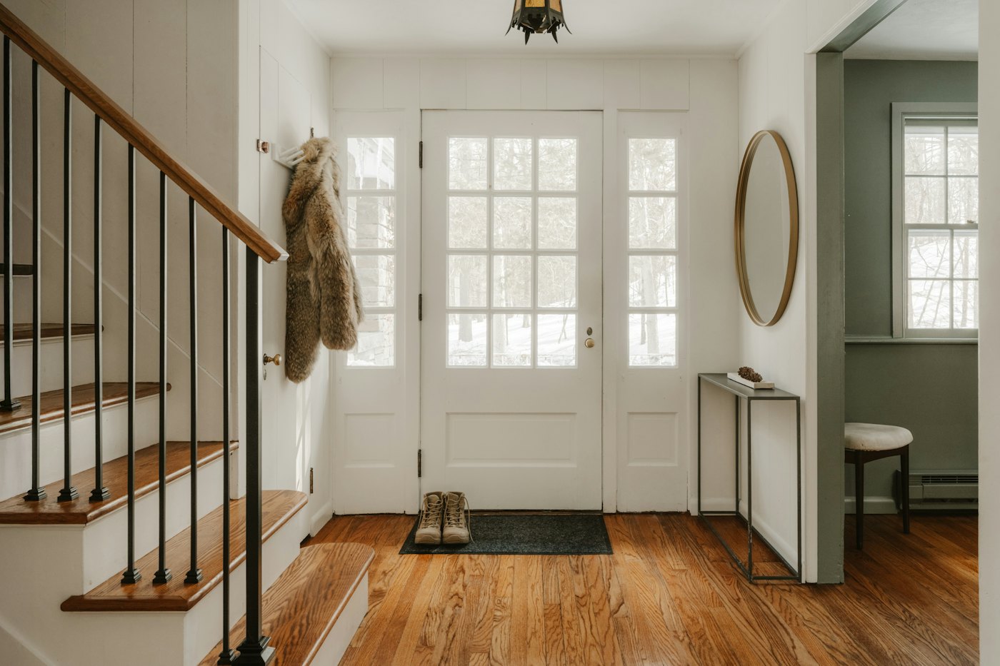 A cozy entryway with wooden stairs and a glass front door